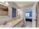 Bright bathroom featuring dual sinks, tile countertops, and a view into the bedroom at 1450 Pinyon Pl, Lawrenceville, GA 30043