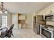 Bright kitchen features stainless appliances, tile flooring, breakfast table, and white cabinets at 1450 Pinyon Pl, Lawrenceville, GA 30043