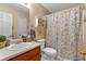 Well-lit bathroom featuring a vanity with sink, toilet, and a shower with patterned curtains for added privacy at 251 Bent Creek Dr, Dallas, GA 30157