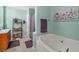 Bright bathroom with a large tub, shelving unit, and colorful floral artwork on the wall at 251 Bent Creek Dr, Dallas, GA 30157