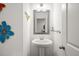 Stylish powder room with pedestal sink, modern mirror, and decorative accents at 2855 Mcmurtry St, Cumming, GA 30041