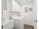 Clean laundry room features white cabinetry and a modern washing machine and dryer at 2855 Mcmurtry St, Cumming, GA 30041