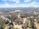 Spacious properties nestled amidst trees with a view of distant mountains under a blue, partly cloudy sky at 6920 Greenfield Ln, Cumming, GA 30028