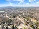 An aerial shot showcases homes nestled among trees with open sky, highlighting the serene residential landscape at 6920 Greenfield Ln, Cumming, GA 30028