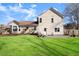 The well-maintained backyard features a lush lawn, a patio with furniture, and the home's charming architectural details at 6920 Greenfield Ln, Cumming, GA 30028