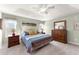 A primary bedroom features a large bed, dresser, and two windows for ample natural light at 6920 Greenfield Ln, Cumming, GA 30028
