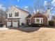 Charming two-story home with a brick and vinyl exterior and dormant lawn at 6920 Greenfield Ln, Cumming, GA 30028