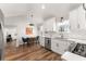 Modern kitchen with stainless steel appliances, white cabinets, and access to dining area with matching floors at 6920 Greenfield Ln, Cumming, GA 30028