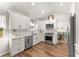 Well-lit kitchen offers stainless steel appliances, sleek countertops, and white cabinets for a modern look at 6920 Greenfield Ln, Cumming, GA 30028