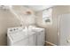 Bright laundry room offers convenience with washer, dryer, and storage shelving at 6920 Greenfield Ln, Cumming, GA 30028