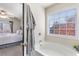 Bright bathroom with a soaking tub under a sunny window at 2450 Mildon Hall Ln, Lawrenceville, GA 30043