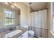 Well-lit bathroom featuring a granite-topped vanity and a shower-tub with a patterned curtain at 840 Wells Se Cir, Smyrna, GA 30080
