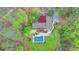 Bird's eye view of the home, deck, and covered in-ground pool surrounded by mature trees and lush landscaping at 311 Maranatha Trl, Lawrenceville, GA 30045