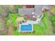 Aerial view showcasing the home's in-ground pool, and large deck with seating, surrounded by lush landscaping at 311 Maranatha Trl, Lawrenceville, GA 30045