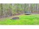 Landscaped backyard with a trampoline and fire pit, perfect for outdoor activities and relaxation at 311 Maranatha Trl, Lawrenceville, GA 30045