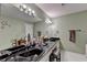 Stylish bathroom with a long vanity, modern lighting, and white tiled floor at 311 Maranatha Trl, Lawrenceville, GA 30045