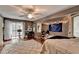 A well-lit bedroom with hardwood floors, a ceiling fan, and a comfortable seating area at 311 Maranatha Trl, Lawrenceville, GA 30045