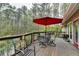 Spacious outdoor deck with a red umbrella and wooded views, perfect for relaxing at 311 Maranatha Trl, Lawrenceville, GA 30045