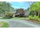 Scenic view of home surrounded by lush trees, a circular driveway, and well-maintained landscaping at 311 Maranatha Trl, Lawrenceville, GA 30045