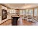 Bright kitchen and dining area featuring white cabinetry, a kitchen island, and hardwood flooring at 311 Maranatha Trl, Lawrenceville, GA 30045