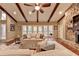 Bright living room featuring exposed wood beams, large windows, and stone fireplace at 311 Maranatha Trl, Lawrenceville, GA 30045