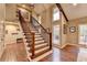 Elegant staircase with wood and iron railing, and natural light from large windows at 311 Maranatha Trl, Lawrenceville, GA 30045