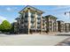 Contemporary apartment building featuring tan brick, black balconies, and commercial space on the ground floor at 5300 Peachtree Rd # 2309, Chamblee, GA 30341