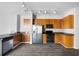 Modern kitchen with stainless steel appliances, wood cabinetry, granite countertops, and wood-look flooring at 5300 Peachtree Rd # 2309, Chamblee, GA 30341