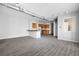 Open-concept living room with gray hardwood floors, track lighting, and a kitchen bar with granite countertop at 5300 Peachtree Rd # 2309, Chamblee, GA 30341