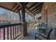 Covered back porch with brick columns, ceiling fan, and comfortable seating area at 91 Webb St, Roswell, GA 30075