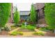 Charming courtyard with colorful flowerbeds, a stone bench, and a view of the townhome exteriors at 91 Webb St, Roswell, GA 30075