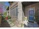 Charming brick townhome entry with a vibrant blue door, screened-in porch, and manicured landscaping at 91 Webb St, Roswell, GA 30075