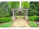 Inviting outdoor gazebo with a stone walkway, pergola, lush greenery, and manicured landscaping at 91 Webb St, Roswell, GA 30075