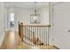 Hallway featuring a decorative chandelier, hardwood flooring, and a staircase with wrought iron spindles and stained handrail at 91 Webb St, Roswell, GA 30075