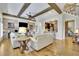 Bright living room with beamed ceiling, built-in cabinets, hardwood floors, and open access to the kitchen area at 91 Webb St, Roswell, GA 30075