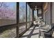 Relaxing screened porch with wicker furniture and views of the landscaped courtyard and flowering tree at 91 Webb St, Roswell, GA 30075