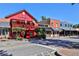 Street view of historic buildings, including Mae McGee's red facade and various storefronts on a sunny day at 91 Webb St, Roswell, GA 30075