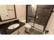 Modern bathroom with sleek vanity, stylish mirror, and walk-in shower featuring dark tile and a sliding glass door at 112 Austin Dr, Sandy Springs, GA 30328