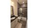 Modern bathroom with sleek vanity, stylish mirror, and walk-in shower featuring dark tile and a sliding glass door at 112 Austin Dr, Sandy Springs, GA 30328