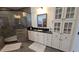 A bathroom featuring a glass shower, tile floor, vanity with black countertops, and storage cabinets at 112 Austin Dr, Sandy Springs, GA 30328