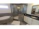 A tiled bathroom featuring a soaking tub, glass shower, and a vanity with a black countertop at 112 Austin Dr, Sandy Springs, GA 30328