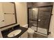 Modern bathroom with sleek vanity, stylish mirror, and walk-in shower featuring dark tile and a sliding glass door at 112 Austin Dr, Sandy Springs, GA 30328