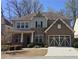 Charming brick and siding two-story home featuring an attached two-car garage and manicured landscaping at 112 Austin Dr, Sandy Springs, GA 30328