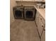 Laundry room with side-by-side washer and dryer units, complemented by white cabinets and countertop space at 112 Austin Dr, Sandy Springs, GA 30328