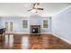Cozy living room featuring hardwood floors, a stone fireplace, and a ceiling fan at 119 Fountain Oak, Villa Rica, GA 30180