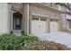 Close up of a two-car garage in a townhome with a brick facade and adjacent front door at 1632 Caswell Pkwy # 8, Marietta, GA 30060
