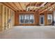 Spacious living room under construction with exposed wooden framing, large windows, and a door to the deck at 1632 Caswell Pkwy # 8, Marietta, GA 30060