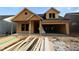 Unfinished exterior view of a two-story home with a two-car garage and exposed wood framework at 2044 Ripple Park Bend, Canton, GA 30114