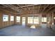 Unfinished living room featuring exposed framing, a concrete floor, and ample natural light at 2044 Ripple Park Bend, Canton, GA 30114