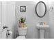 Cozy powder room with pedestal sink, round mirror, and decorative accents at 2527 Hedgeway Cir, Kennesaw, GA 30144